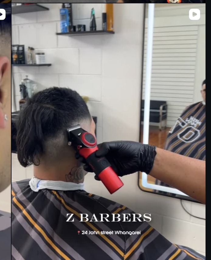 Barber working a fade with clippers at Z Barbers, seen in the mirror