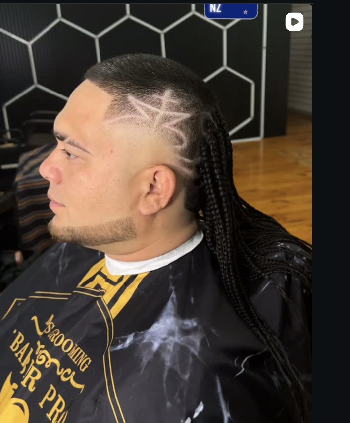 Star and web design razored above the ear, worn with long braids